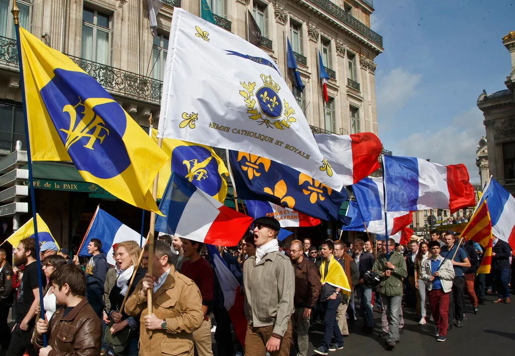 French monarchists of the Action Francaise Party march with French and party flags during a rally to honor Joan of Arc Day.