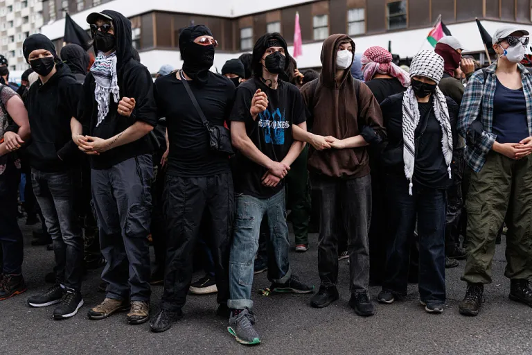 People associated with the 'anti fascist' movement form a line outside the Barbican Thistle Hotel as anti-immigration, 'stand up to racism' and 'anti-fascist' groups all gather outside on August 2, 2025 in London, England. Protests outside hotels housing asylum seekers have increased in recent weeks, organised by far-right protest groups such as the Democratic Football Lads Alliance (DFLA). Stand Up To Racism (SUTR) holding counter-protests defending refugees have taken place at many of the sites, with more protests expected over the summer. (Photo by Dan Kitwood/Getty Images)