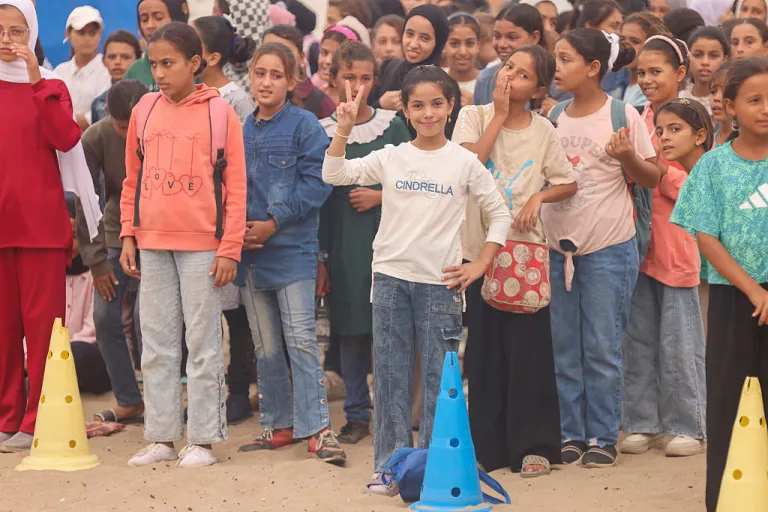 A Palestinian girl flashes a victory sign during celebrations in Al-Mawasi, Rafah, Gaza Strip, on October 9, 2025, following news of a new Gaza ceasefire deal. Israel and Hamas agree on October 9 to a Gaza ceasefire and hostage deal after two years of war in Gaza. (Photo by Abdelrahman Rashad / Middle East Images via AFP) (Photo by ABDELRAHMAN RASHAD/Middle East Images/AFP via Getty Images)