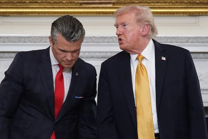 President Donald Trump talks with Defense Secretary Pete Hegseth after a roundtable on criminal cartels in the State Dining Room of the White House, Thursday, Oct. 23, 2025, in Washington.
