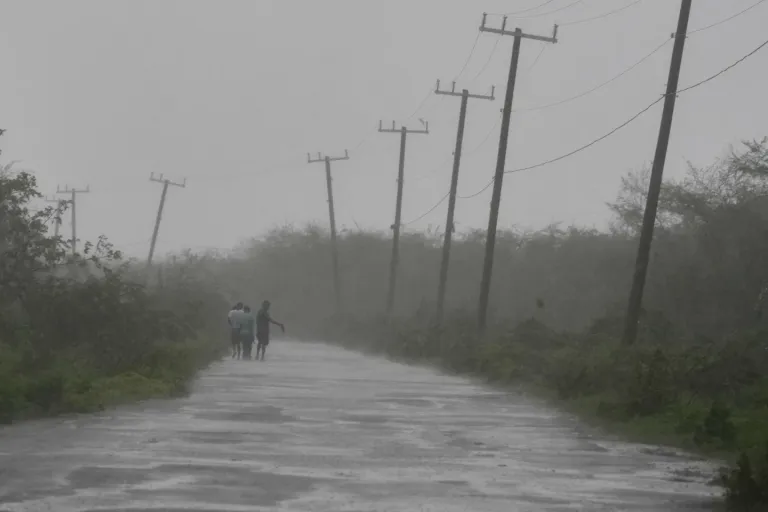 4 of 8 | People walk along a road during the passing of Hurricane Melissa in Rocky Point, Jamaica, Tuesday, Oct. 28, 2025. (AP Photo/Matias Delacroix)