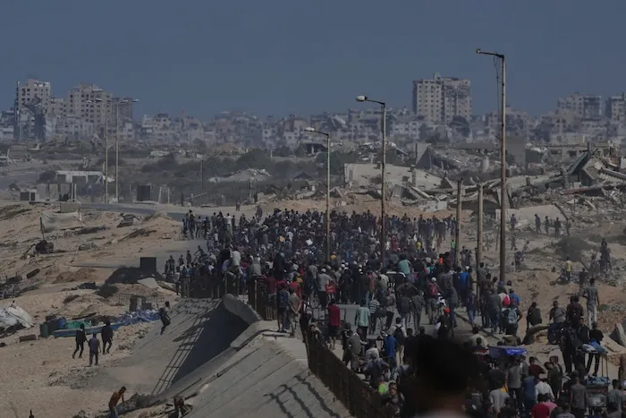Displaced Palestinians walk along the coastal road near Wadi Gaza in the central Gaza Strip, moving toward northern Gaza, Friday, Oct. 10, 2025, after Israel and Hamas have agreed to a pause in their war and the release of the remaining hostages. (AP Photo/Abdel Kareem Hana)