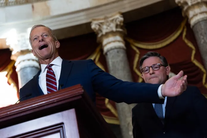 Senate Majority Leader John Thune (R-SD) speaks as House Speaker Mike Johnson (R-LA) listens behind him.