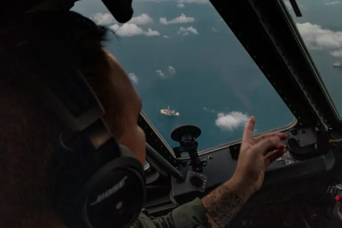 Lt. Carl Weaver points to an oil rig from onboard HC-144B Maritime Patrol Aircraft off the coast of Padre Island, Texas.