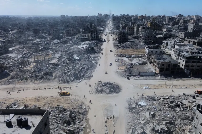 Palestinians walk among the rubble of Gaza City