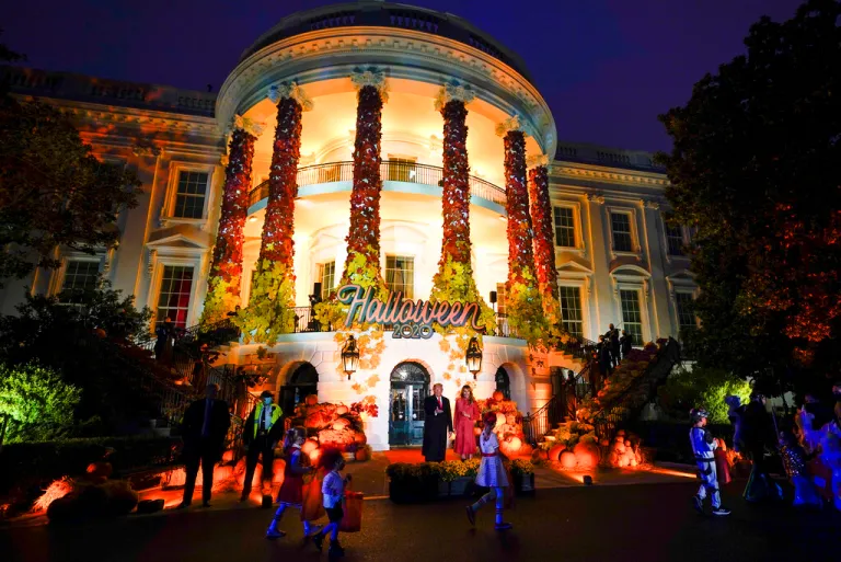 President Donald Trump and first lady Melania Trump greet trick-or-treaters on the South Lawn of the White House.