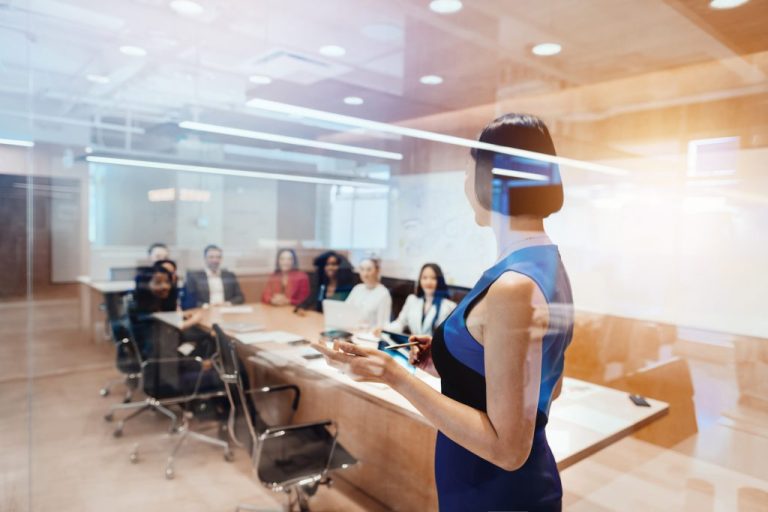Korean businesswoman leads colleagues in a meeting.