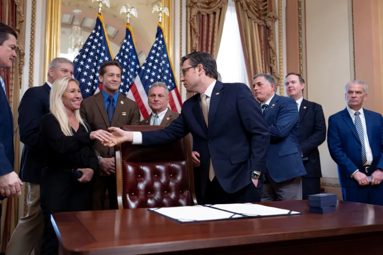 Mike Johnson shakes Marjorie Taylor Greene's hand.