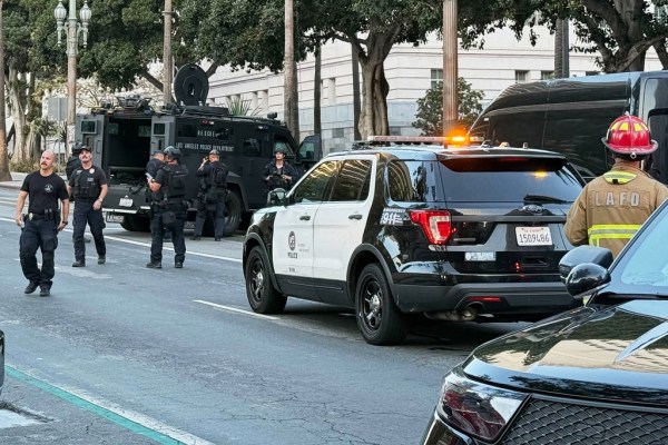 Man with signs referencing Trump barricades himself inside car outside Los Angeles City Hall