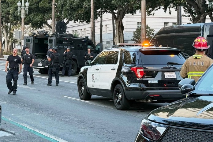 Man with sign referencing Trump barricades himself inside car outside Los Angeles City Hall