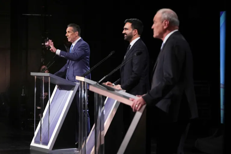 Zohran Mamdani, Andrew Cuomo and Curtis Sliwa stand at podiums during the candidates' debate