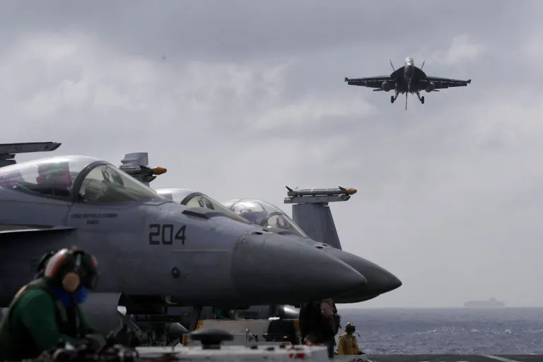 F18 Super Hornet jet lands on carrier.