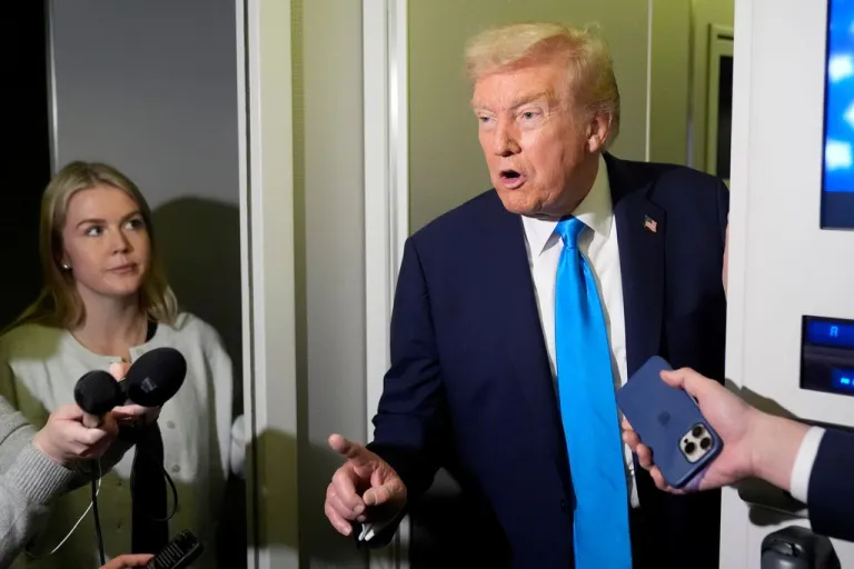 President Donald Trump speaks with reporters as White House press secretary Karoline Leavitt listens aboard Air Force One.
