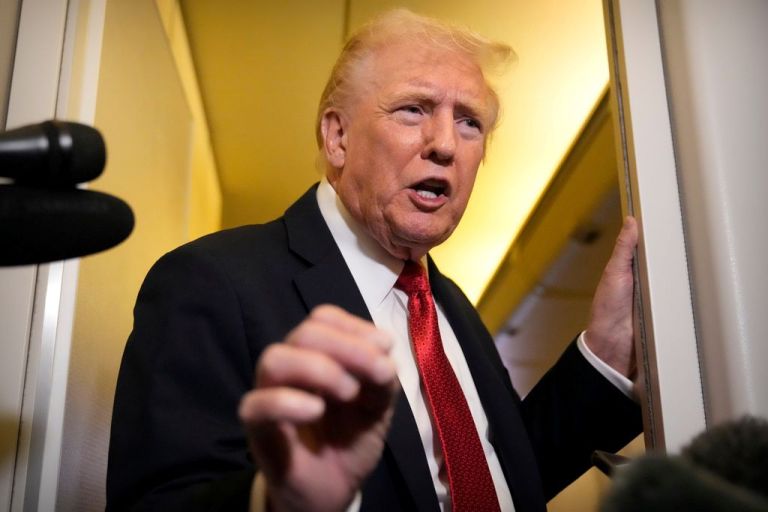Trump speaks to reporters aboard Air Force One.
