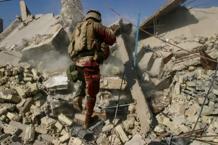 A Marine searches through the rubble of a bombed-out building in Fallujah, Iraq. (Photo shared by Manifold Productions)