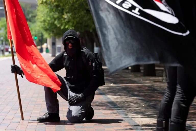 Anti-fascist protesters hold flags on the Christian Science Plaza in Boston.