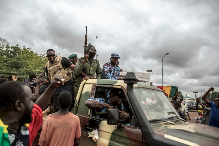 People cheer in celebration as security forces drive through the streets of the capital Bamako, Mali, Wednesday, Aug. 19, 2020, a day after armed soldiers fired into the air outside President Ibrahim Boubacar Keita's home and took him into their custody. Not everyone is hostile to last week's coup in Niger. Neighboring Burkina Faso and Mali have taken the unusual step of declaring that foreign military intervention in Niger would be a declaration of war against them, too. Both have had coups in recent years.