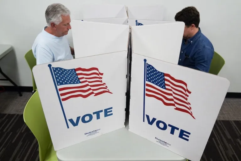 People mark their ballots at the polling place.