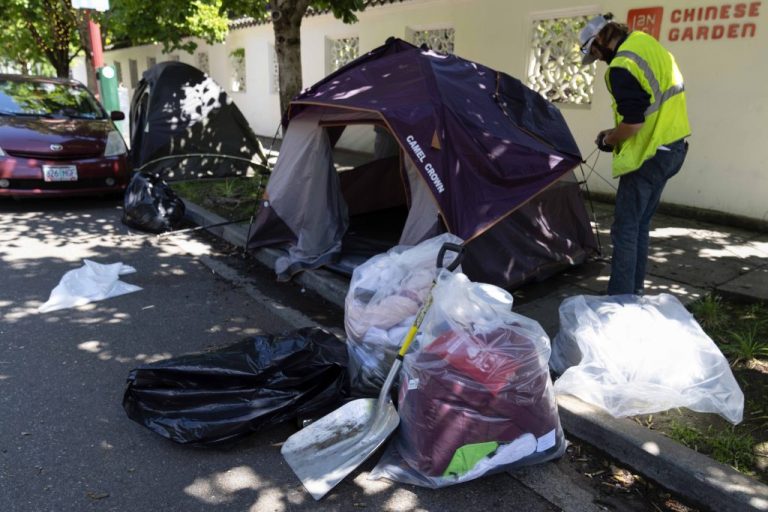 Contents of a tent in bags as workers dismantle the tent.