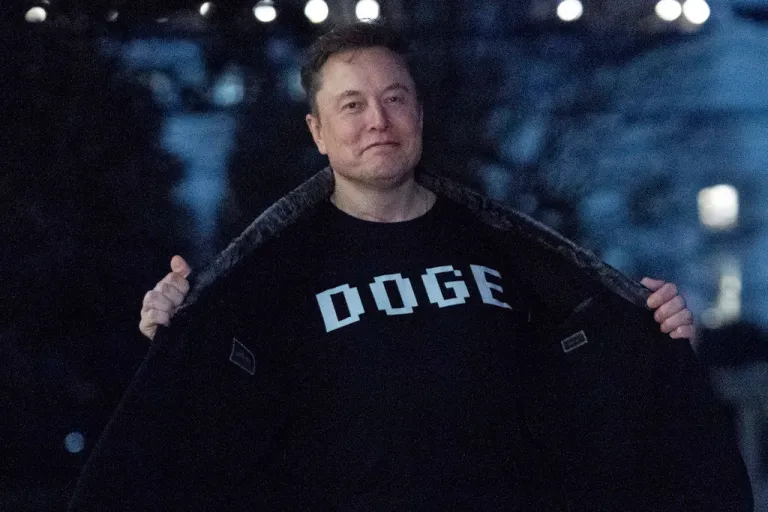 Elon Musk flashes his T-shirt that reads 