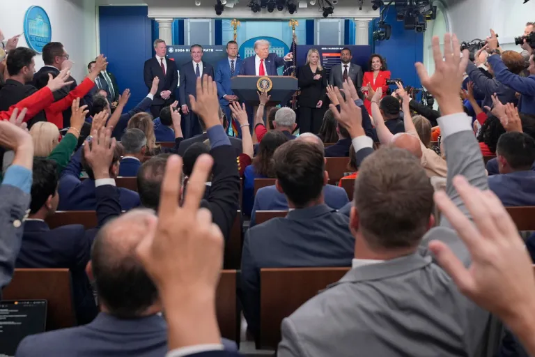 President Donald Trump, center, points to members of the media as he speaks with reporters.