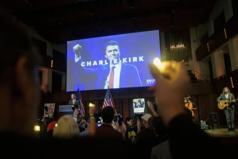 People hold candles and sing during a memorial and prayer vigil for Charlie Kirk at the John F. Kennedy Memorial Center for the Performing Arts, Sunday, Sept. 14, 2025, in Washington.