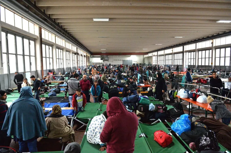 Refugees wait in a crowded migrant registration center.