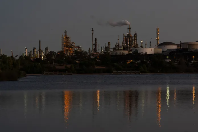 Lights from the Phillips 66 Los Angeles Refinery Wilmington Plant are reflected in the water at dusk.