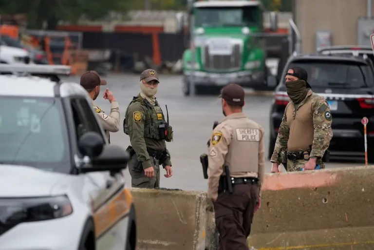 Cook County Sheriff's deputies and federal agents talk outside an Immigration and Customs Enforcement building.