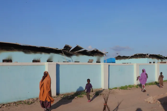 People walk past torched houses following an attack by Boko Haram in Darul Jamal, Nigeria.