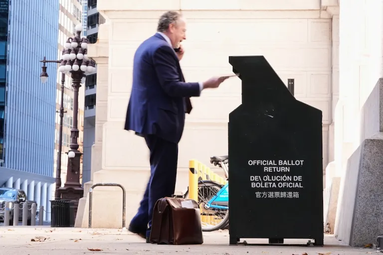 A person places an envelope in a ballot return box for mail-in ballots outside of City Hall in Philadelphia, Monday, Oct. 27, 2025. (AP Photo/Matt Rourke)