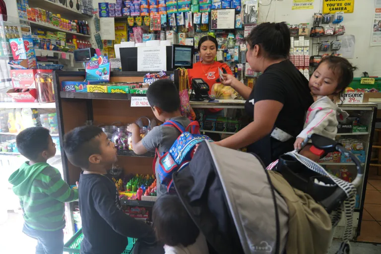 An immigrant mother originally from Guatemala purchases fresh bananas for her children.