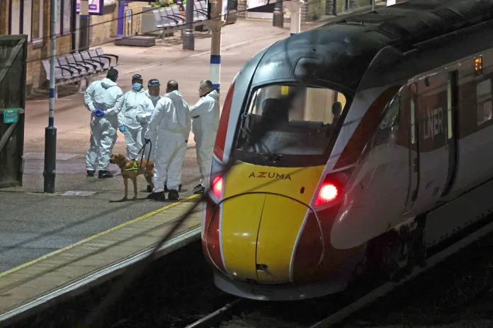 Forensic investigators on the platform by a train at Huntingdon station after a mass stabbing on a London-bound train in eastern England, in Cambridgeshire, England, Saturday, Nov. 1, 2025.