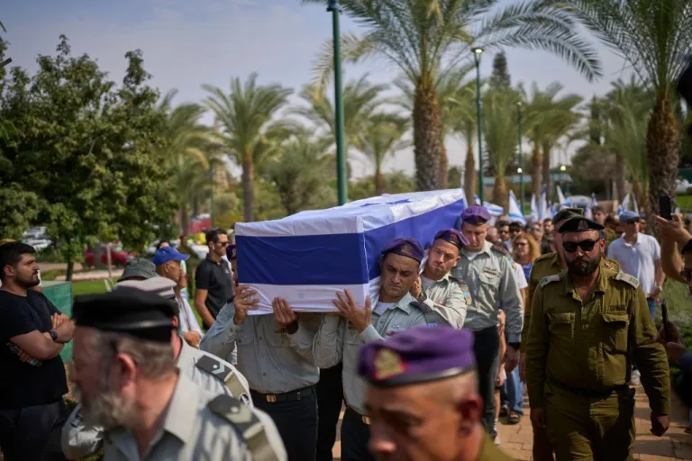 Israeli soldiers carry the flag-draped coffin of slain hostage Col. Asaf Hamami, who was was abducted by Hamas militants on Oct. 7, 2023, during his funeral at Kiryat Shaul military cemetery, in Tel Aviv, Israel, Tuesday, Nov. 4, 2025. Hamami