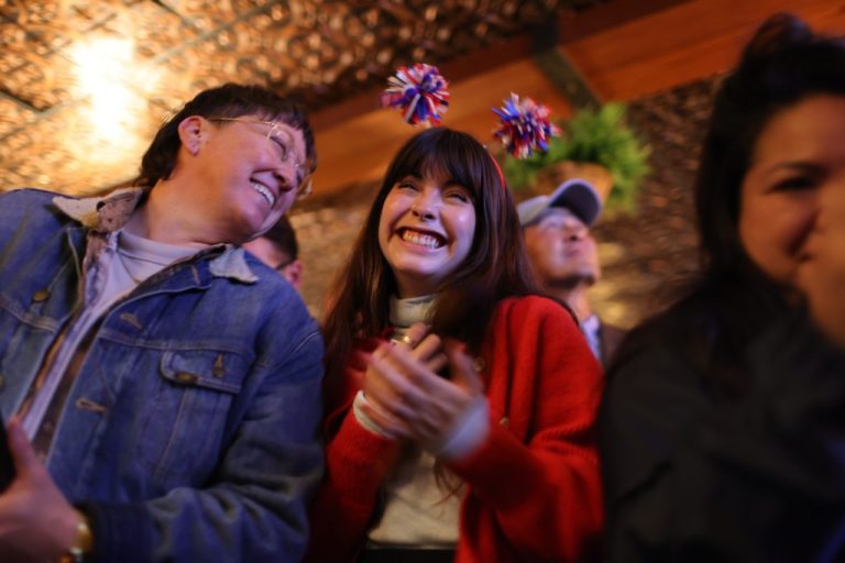 Women smile at a Prop 50 election night party in San Francisco.