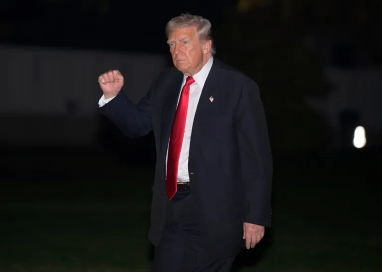 President Donald Trump gestures as he walks across the South Lawn upon arrival at the White House in Washington, Sunday, Nov. 9, 2025.