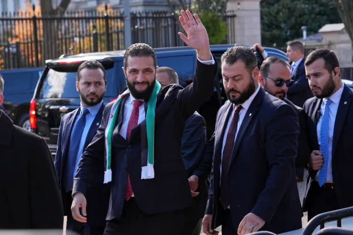 Syrian President Ahmed al Sharaa waves as he greets supporters outside the White House.