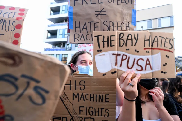 Protesters with signs stand outside a Turning Point USA event at the University of California, Berkeley.