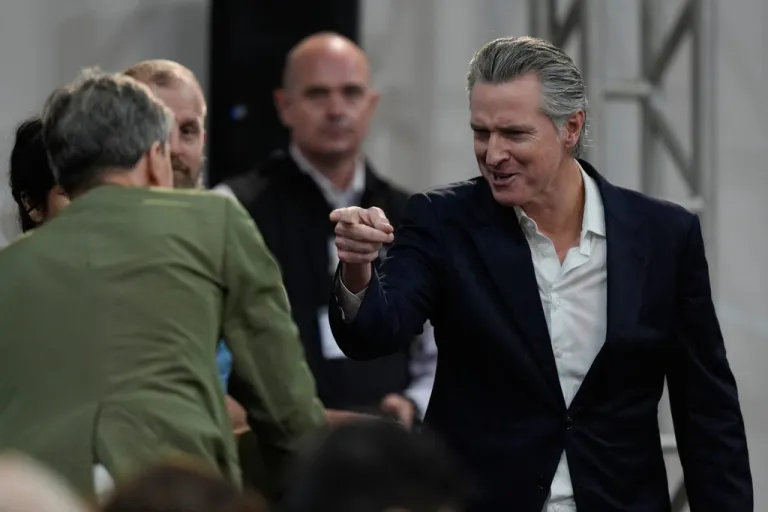 California Gov. Gavin Newsom, right, gestures as he arrives for a news conference at the COP30 U.N. Climate Summit, Tuesday, Nov. 11, 2025, in Belem, Brazil. (AP Photo/Fernando Llano)