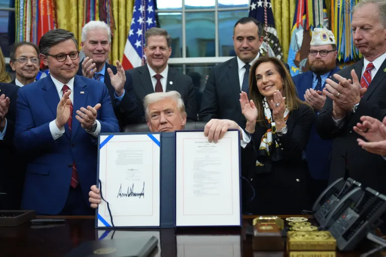 President Donald Trump displays the signed funding bill to reopen the government,