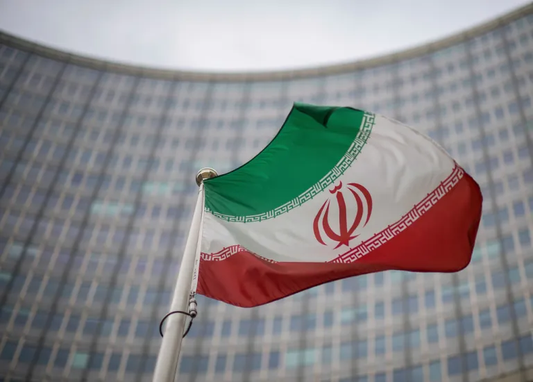 A national flag of Iran waves in front of the building of the International Atomic Energy Agency.