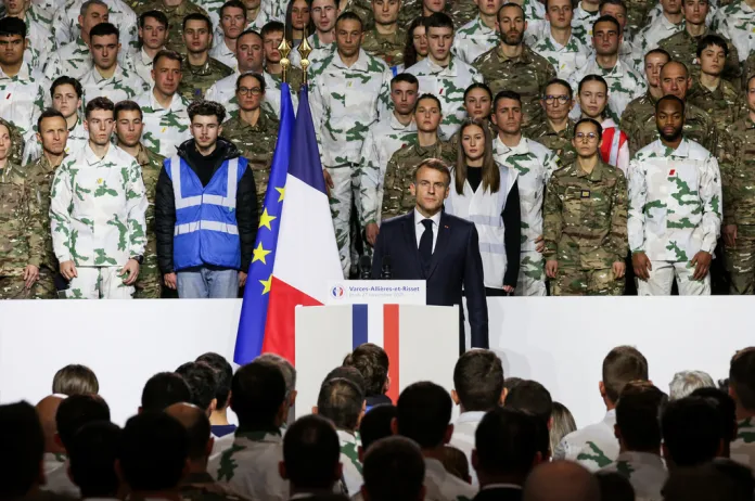 President Emmanuel Macron stands for the national anthem