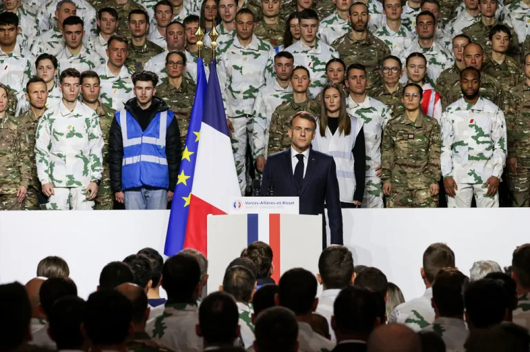 President Emmanuel Macron stands for the national anthem