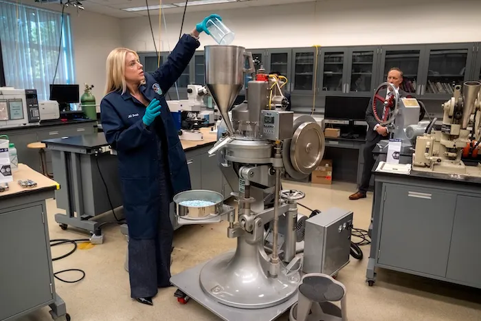 Attorney General Pam Bondi adds a mixture simulating the ingredients of fentanyl pills into a tablet press machine at a Drug Enforcement Administration (DEA) research laboratory on Tuesday, April 29, 2025, in Northern Virginia. (AP Photo/Mark Schiefelbein)