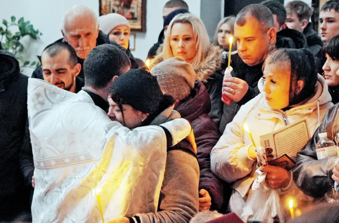 A priest comforts a worshipper at the funeral for a 17-year-old girl killed by Russian shelling in Berestyn, Kharkiv Oblast, Ukraine, Nov. 19, 2025. (Viktoriia Yakymenko/Suspilne Ukraine/JSC “UA:PBC”/Global Images Ukraine/Getty)