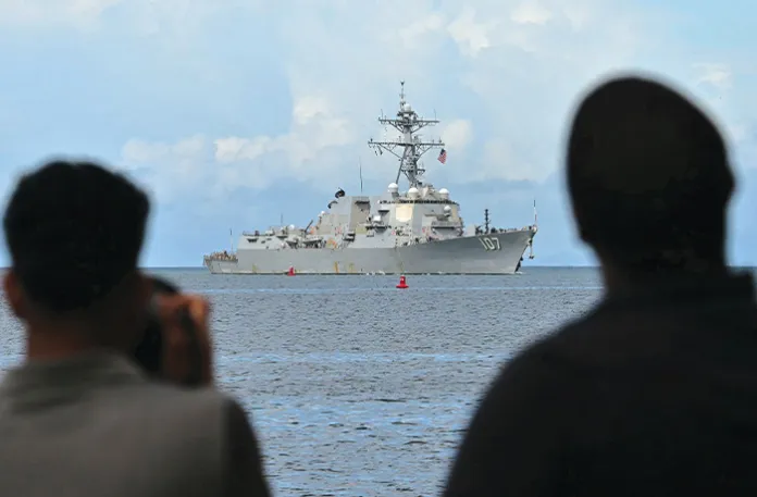 Spectators watch as the USS Gravely enters Trinidad and Tobago’s Port of Spain on Oct. 26. The U.S. warship is in the region for joint exercises near the coast of Venezuela amid Washington’s campaign against alleged drug traffickers. (MARTIN BERNETTI/AFP via Getty Images)