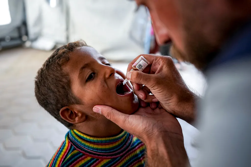 A health worker administers a polio vaccine to a child at a hospital in Deir al-Balah, central Gaza Strip, Sunday, Sept. 1, 2024. (AP Photo/Abdel Kareem Hana)