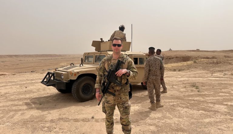 Michael Bouchard in front of a Humvee.