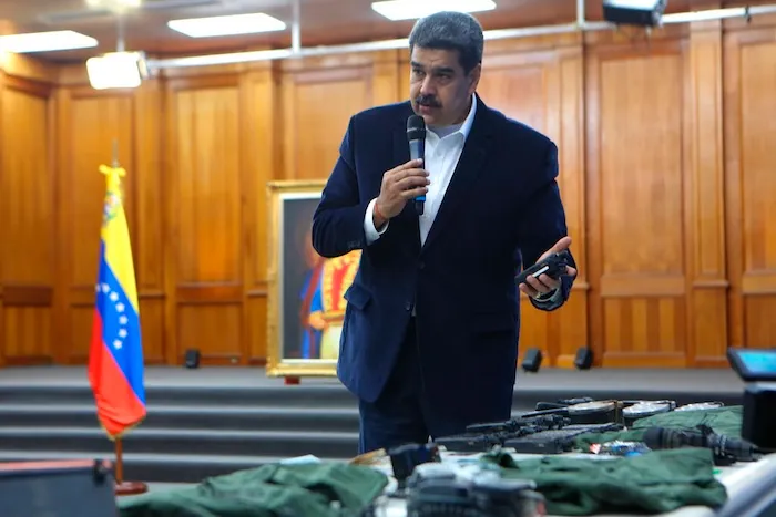 This photo released by the Venezuelan Miraflores presidential press office shows President Nicolas Maduro speaking over military equipment that he says was seized during an incursion into Venezuela, during his televised address from Miraflores in Caracas, Venezuela, Monday, May 4, 2020. Maduro said authorities arrested two U.S. citizens among a group of “mercenaries” on Monday, a day after a beach raid purportedly aimed at capturing the leader that Venezuelan authorities say they foiled. (Miraflores press office via AP)