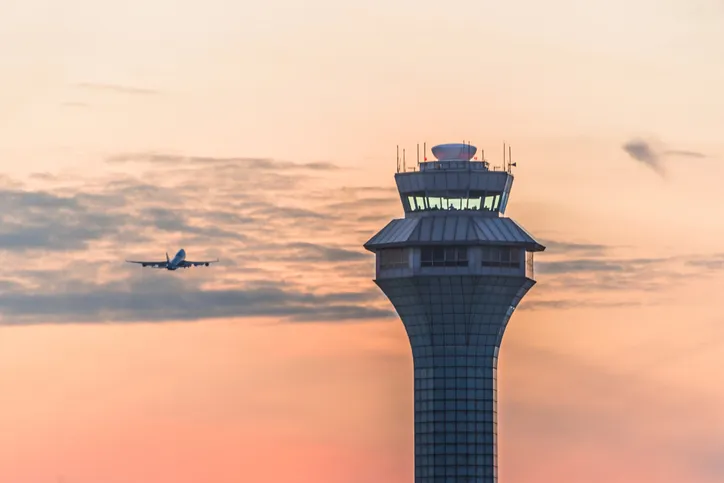 Airport traffic control tower at sunset.